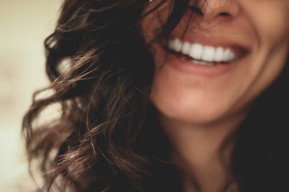 lächelnde Frau mit dunklen, lockigen Haaren